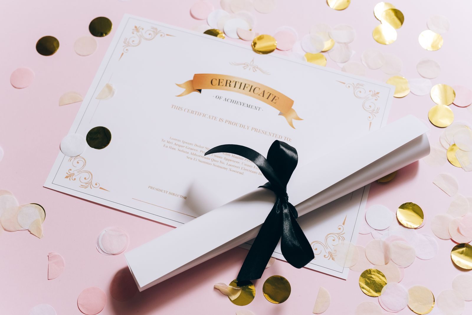 Certificate of achievement and a rolled diploma tied with ribbon, a nod to CLIA certification