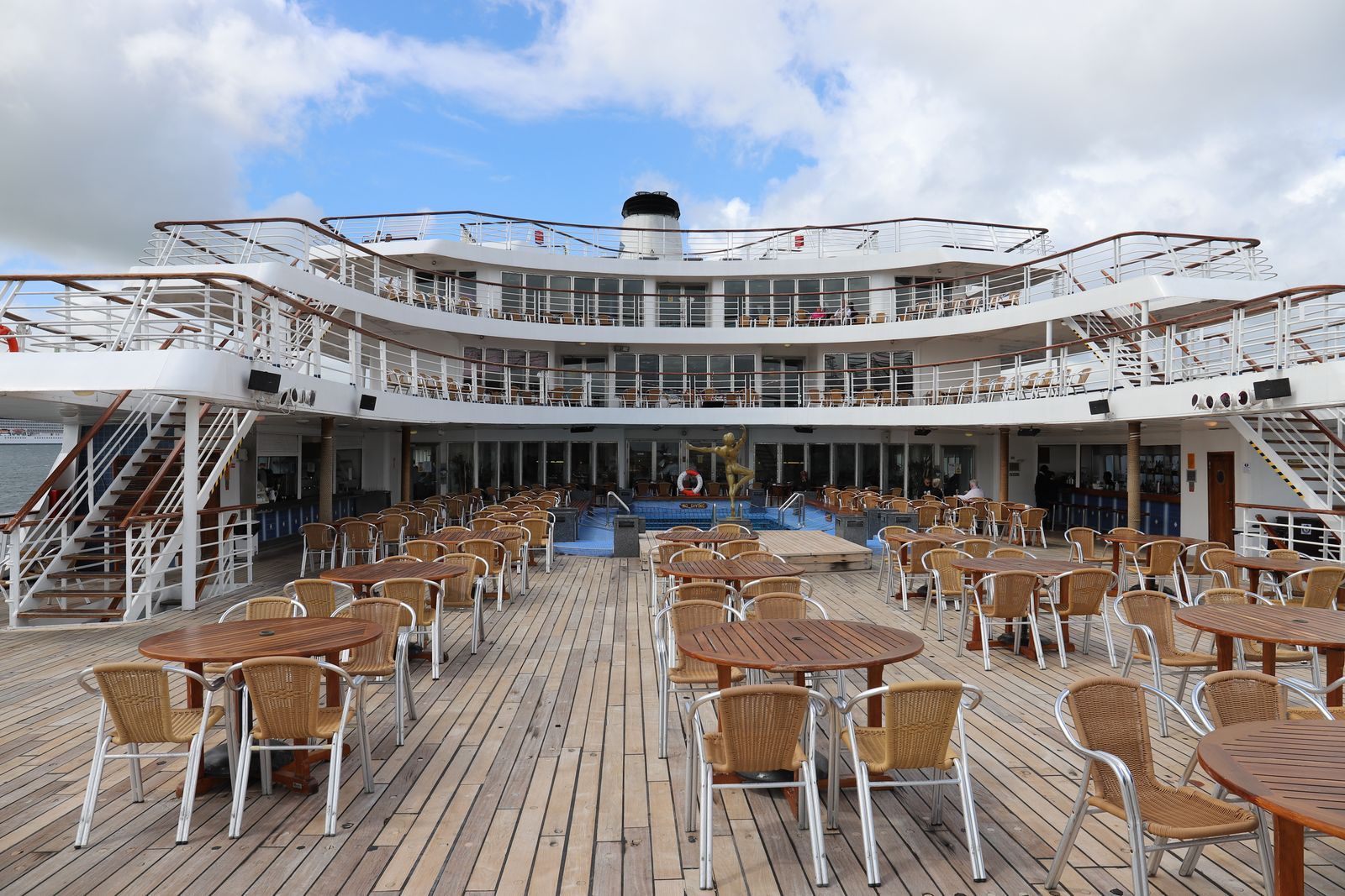 Open aft deck of a cruise ship set with tables and chairs, the product cruise line travel agent certification teaches