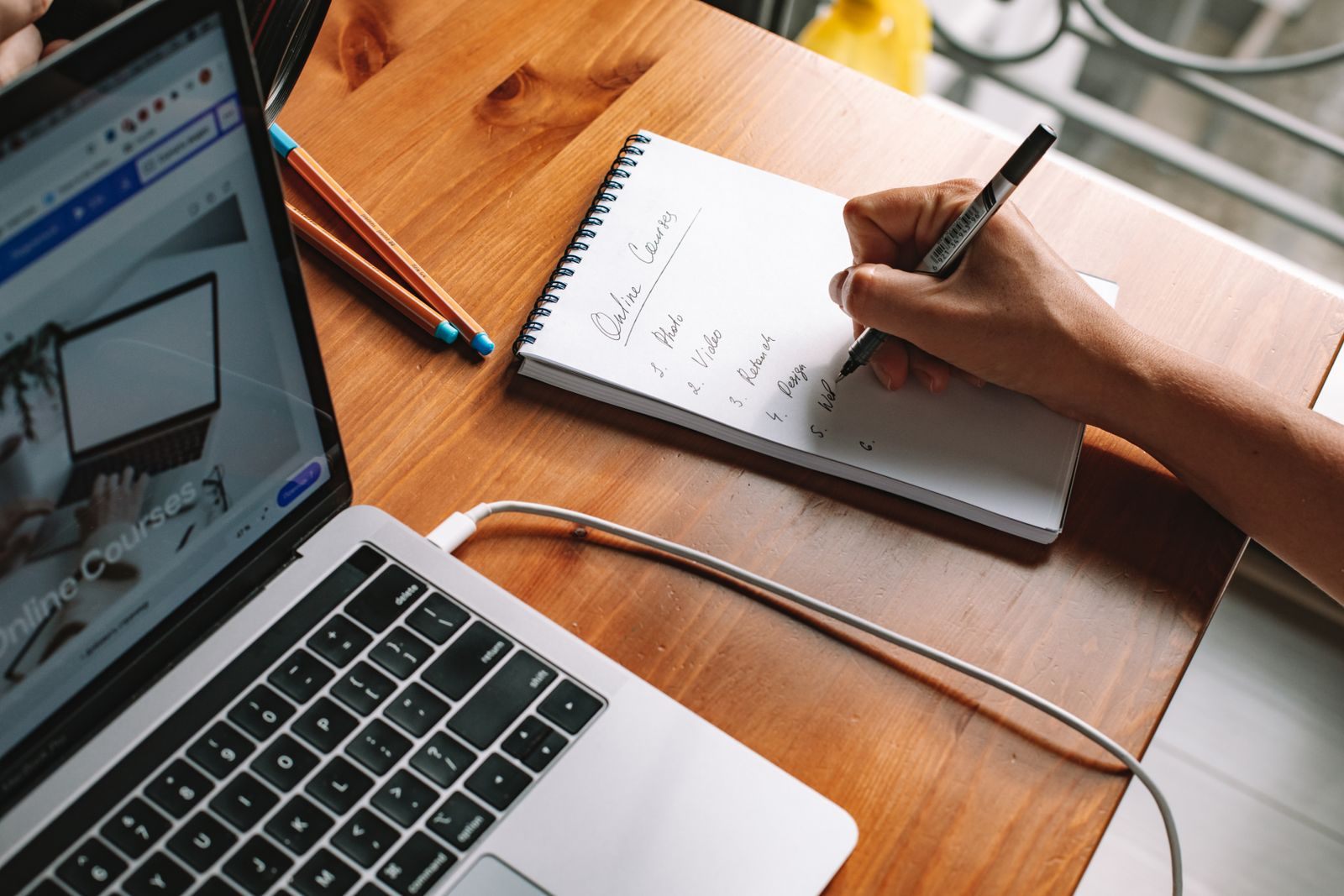 Laptop and handwritten notes on a desk during cruise travel agent training online